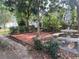 Backyard with patio, concrete benches, and lush garden at 1408 Torrey Pines Dr, Lady Lake, FL 32159