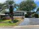 Charming single story home with a carport, a palm tree, and a well-maintained yard at 1408 Torrey Pines Dr, Lady Lake, FL 32159