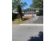 Charming single-story home with a bright sunroom, landscaped yard, and paved driveway at 1408 Torrey Pines Dr, Lady Lake, FL 32159