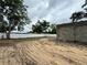 The grey block walls of a home under construction next to a white fence and lot with sandy soil at 15106 Se 94Th Ter, Summerfield, FL 34491