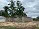 The grey block walls of a partially constructed home site with trees under a cloudy sky at 15106 Se 94Th Ter, Summerfield, FL 34491