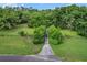 A scenic view of land with lush greenery, trees, and a long driveway leading to the property at 16120 Nw Us Highway 27, Williston, FL 32696