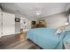 Well-lit bedroom features hardwood floors, ceiling fan, and a glimpse into the ensuite bathroom at 16193 Sw 14Th Avenue Rd, Ocala, FL 34473