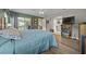 Spacious bedroom featuring wood floors, a ceiling fan, and access to the sunroom and ensuite bathroom at 16193 Sw 14Th Avenue Rd, Ocala, FL 34473
