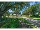 Picturesque community entrance with lush greenery, a brick pathway, and stately trees creating a welcoming ambiance at 16193 Sw 14Th Avenue Rd, Ocala, FL 34473