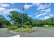 Scenic community entrance featuring a flagpole, colorful flowers, and well-maintained landscaping under a blue sky at 16193 Sw 14Th Avenue Rd, Ocala, FL 34473