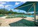 Relaxing view of the community pool with ample seating and shade, set against a backdrop of palm trees and clear skies at 16193 Sw 14Th Avenue Rd, Ocala, FL 34473