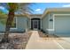 Close-up of the front entrance showing landscaped features leading to the screened front door at 16193 Sw 14Th Avenue Rd, Ocala, FL 34473