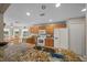 Open kitchen with granite counters, wooden cabinets and white appliances at 16193 Sw 14Th Avenue Rd, Ocala, FL 34473