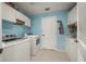 Functional laundry room with white cabinets, modern washer and dryer, and bright blue walls at 16193 Sw 14Th Avenue Rd, Ocala, FL 34473