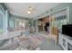 Bright sunroom with a ceiling fan, decorated with a vibrant rug, and open to the living areas at 16193 Sw 14Th Avenue Rd, Ocala, FL 34473