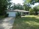 Well-kept home with a lush lawn, attached garage, and inviting screened porch entrance at 19026 Sw 100Th Pl, Dunnellon, FL 34432