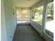 A covered and screened in front porch with railings, offering a comfortable outdoor space at 19026 Sw 100Th Pl, Dunnellon, FL 34432