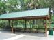 A community picnic shelter with a green metal roof and several picnic tables at 19026 Sw 100Th Pl, Dunnellon, FL 34432