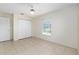 Comfortable bedroom with tile flooring, a ceiling fan, a window, and closet space for storage at 21 Pine Trace Run, Ocala, FL 34472