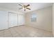 Bedroom with tile flooring, natural light, ceiling fan and closet space, offering a practical and peaceful environment at 21 Pine Trace Run, Ocala, FL 34472