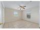 Well-lit bedroom with tile flooring, two windows, and a ceiling fan, offering a serene and cozy atmosphere at 21 Pine Trace Run, Ocala, FL 34472