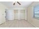Bright bedroom with neutral walls, tile flooring, and convenient built-in closet space at 21 Pine Trace Run, Ocala, FL 34472