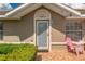 Close up of front door and pink Adirondack chairs on a patterned tile porch at 21 Pine Trace Run, Ocala, FL 34472
