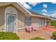 Charming front entrance with pink chairs on a tile patio and a well-lit doorway at 21 Pine Trace Run, Ocala, FL 34472