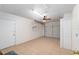 Spacious garage featuring tile flooring, a ceiling fan, natural light, and storage, offering functionality at 21 Pine Trace Run, Ocala, FL 34472