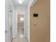 Hallway view showcases the home's layout and access to bathroom, with beige colored wall at 21 Pine Trace Run, Ocala, FL 34472