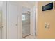 Open hallway leads to the living room, featuring a digital thermostat on a neutral wall at 21 Pine Trace Run, Ocala, FL 34472