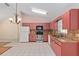 Bright kitchen showcasing appliances, and a tiled floor layout, blending functionality with a cozy aesthetic at 21 Pine Trace Run, Ocala, FL 34472
