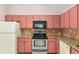 Detailed view of the kitchen showcasing pink cabinets, tile backsplash, and modern appliances at 21 Pine Trace Run, Ocala, FL 34472