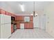 Well-lit kitchen with white tile flooring, stainless steel appliances, and pink cabinets at 21 Pine Trace Run, Ocala, FL 34472