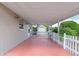 Covered patio area with white picket fence, leading to a storage shed at 21 Pine Trace Run, Ocala, FL 34472