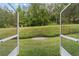 Backyard view from screened-in lanai with lush green lawn and landscaping, offering privacy and a relaxing setting at 2631 Sw 20Th Cir, Ocala, FL 34471