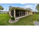 Exterior shot of backyard with screened-in porch showing manicured lawn, clean siding, and simple roofline at 2631 Sw 20Th Cir, Ocala, FL 34471