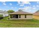 Backyard exterior shot of a home featuring roofline, siding, simple windows, and adjacent manicured yard at 2631 Sw 20Th Cir, Ocala, FL 34471