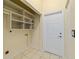 Laundry room with tile floor, overhead cabinets and storage baskets, providing efficient space for chores at 2631 Sw 20Th Cir, Ocala, FL 34471