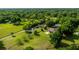 Wide aerial shot displaying several houses with green lawns, mature trees, and a long driveway at 465 Ne 155Th Street Rd, Citra, FL 32113