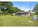 View of the expansive backyard featuring a screened-in patio and mature trees at 465 Ne 155Th Street Rd, Citra, FL 32113