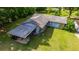 Aerial view of a property, featuring a covered carport, lush lawn, and mature trees at 465 Ne 155Th Street Rd, Citra, FL 32113