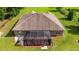 Aerial view of the home's rear exterior, featuring a screened lanai and well-maintained landscaping at 465 Ne 155Th Street Rd, Citra, FL 32113