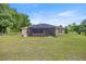The rear exterior shows a screened lanai and a spacious backyard at 465 Ne 155Th Street Rd, Citra, FL 32113