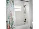 Bathroom showcasing a shower with hexagonal tile, matte black fixtures, and a floral shower curtain at 5330 Ne 111Th Lane Rd, Anthony, FL 32617