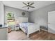 Bedroom with wood-look tile flooring, ceiling fan, white furnishings, and a sunny window view at 5330 Ne 111Th Lane Rd, Anthony, FL 32617