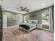 Spacious bedroom featuring wood-look flooring, stylish decor, a ceiling fan, and dual windows at 5330 Ne 111Th Lane Rd, Anthony, FL 32617