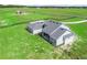 Aerial view of house with grey roof, patio, and surrounding green lawn at 5330 Ne 111Th Lane Rd, Anthony, FL 32617