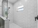 Contemporary walk-in shower featuring white hexagon tile, black trim and fixtures, and natural light at 5330 Ne 111Th Lane Rd, Anthony, FL 32617