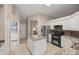 Bright kitchen features white cabinets, stainless steel appliances, tile floors, and an island with granite countertops at 5661 Nw 96Th Ln, Ocala, FL 34482