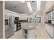 Bright and open kitchen with white cabinets, stainless steel appliances, granite countertops, and abundant natural light at 5661 Nw 96Th Ln, Ocala, FL 34482