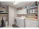Functional laundry room with washer, dryer, ample storage, and utility sink at 5661 Nw 96Th Ln, Ocala, FL 34482