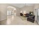 Open-concept living room with tile flooring and arched doorways leads to the dining area and enclosed patio at 5661 Nw 96Th Ln, Ocala, FL 34482