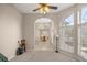 Bright living room featuring large windows, a ceiling fan, and view into the dining room with chandelier at 5661 Nw 96Th Ln, Ocala, FL 34482